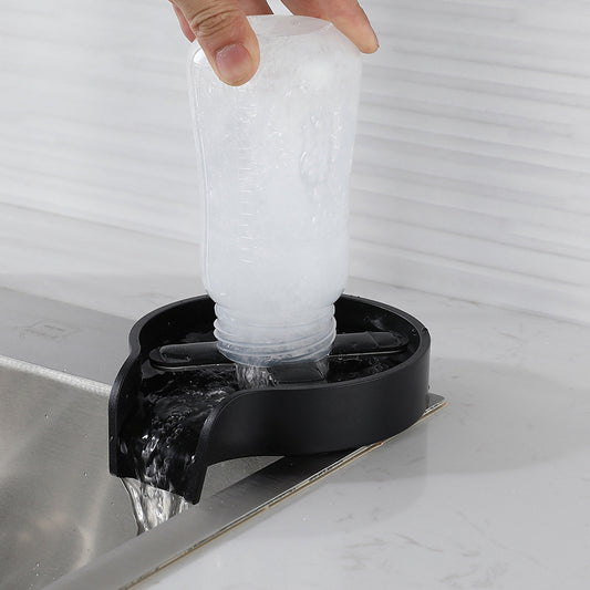 Instant Glass Rinser Homis washing a bottle with high-pressure water stream in kitchen sink.